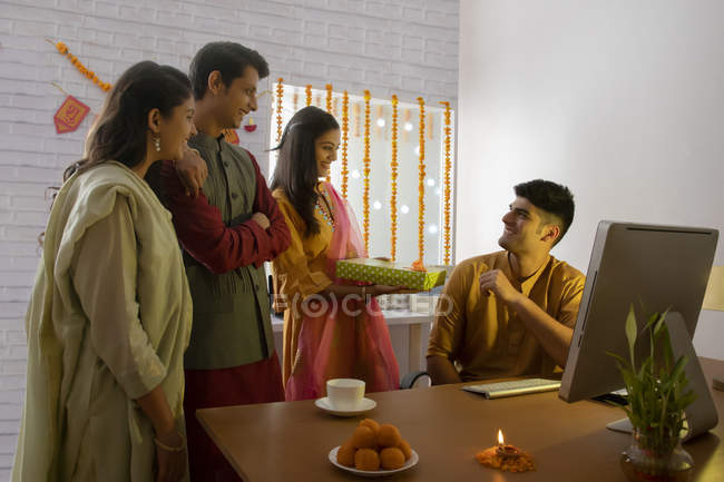 Colleagues giving gift to each other in office on the occasion of Diwali. — Stock Photo