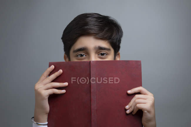 Portrait of a young boy holding a book in hand. — Stock Photo