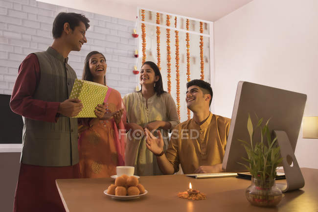 Сотрудники, дарящие подарок коллеге в офисе по случаю празднования Дивали . — стоковое фото