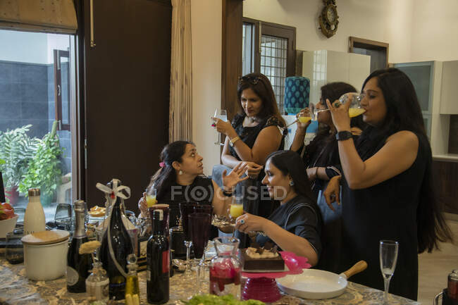 Дамы в черных платьях наслаждаются напитками на вечеринке Китти
. — стоковое фото
