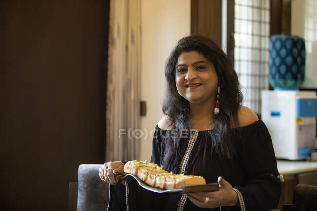 Portrait of a woman holding a plate of snacks. — Stock Photo