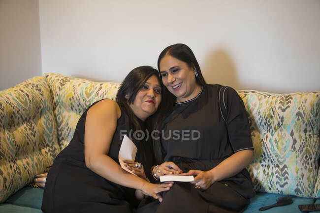 Two friends sitting together on the couch at home. — Stock Photo