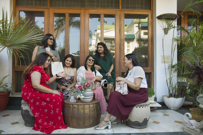 Las mujeres charlando juntos en el patio trasero durante una reunión . - foto de stock