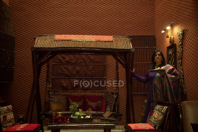 Mujer sosteniendo una bandeja llena de diyas en su casa . - foto de stock