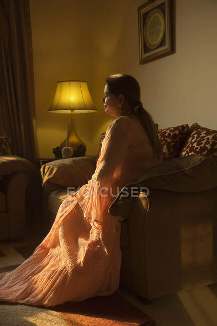 Eine gut gekleidete Frau sitzt gemütlich zu Hause. — Stockfoto