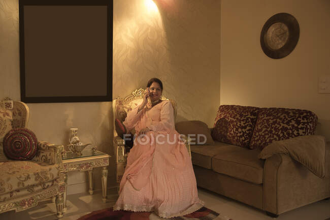 Mujer sentada elegantemente en su casa . - foto de stock