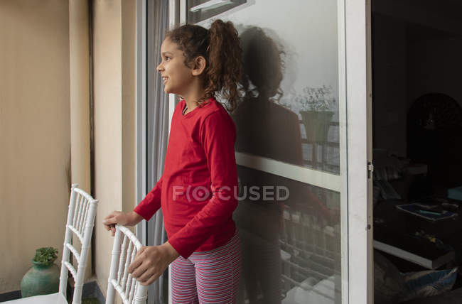 Chica joven de pie en el balcón en casa . - foto de stock