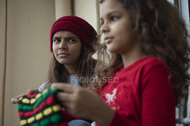Девушка сидит на балконе и подозрительно смотрит на младшую сестру. . — стоковое фото