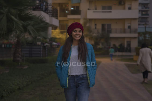 Young girl in winter clothes smiling while walking around. — Stock Photo