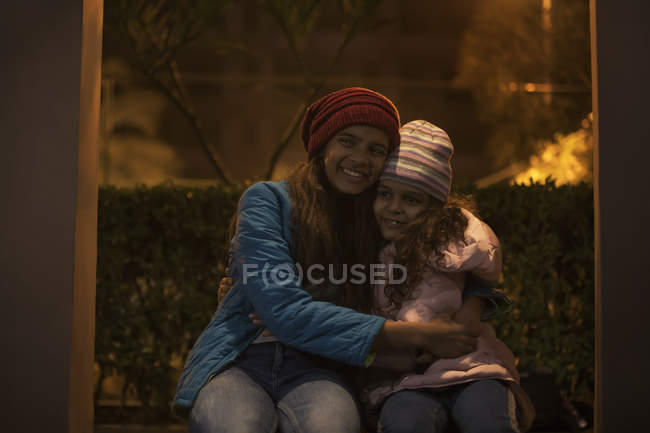 Hermanas jóvenes abrazándose fuera . - foto de stock