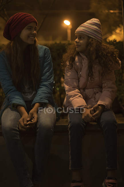 Young sisters sharing a light moment together outside. — Stock Photo