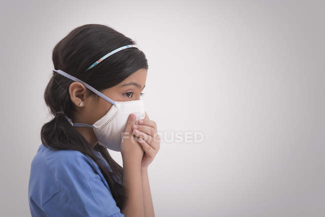 Young girl wearing pollution mask and covering her nose. — Stock Photo