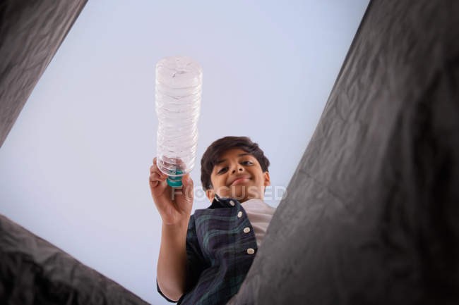Young boy throwing waste in a garbage bag. — Stock Photo