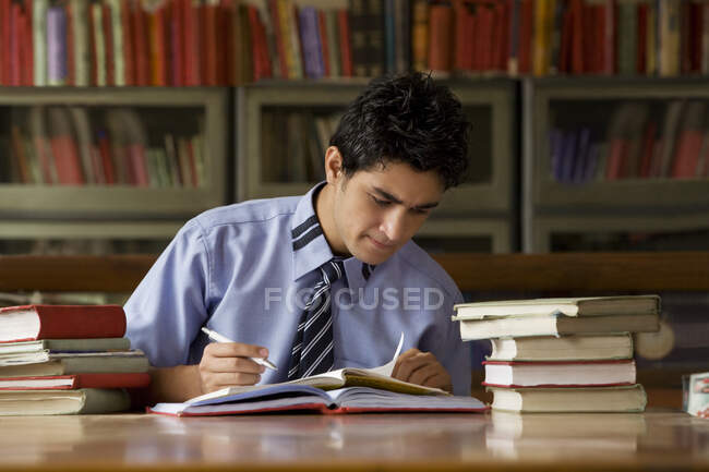 Хлопчик вчиться у шкільній бібліотеці. — стокове фото