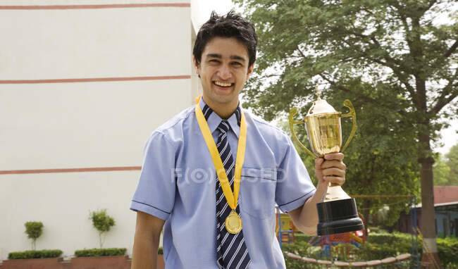 Étudiant garçon tenant un trophée — Photo de stock