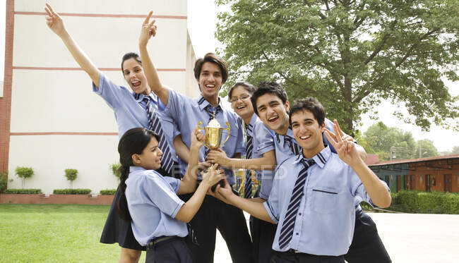 Estudiantes sosteniendo un trofeo juntos - foto de stock