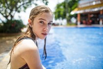 Una chica pensativa se está relajando al lado de una piscina . - foto de stock