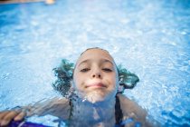 A girl is having fun in a swimming pool during vacation. — Stock Photo