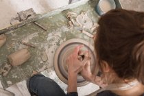 A ceramic artist shaping pottery clay on a pottery wheel in a ceramic workshop. — Stock Photo