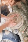 Um artista cerâmico moldando argila de cerâmica em uma roda de cerâmica em uma oficina de cerâmica . — Fotografia de Stock