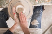 Un artista della ceramica che modella argilla su una ruota di ceramica in un laboratorio di ceramica . — Foto stock