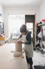 Un artista della ceramica sta mettendo i tocchi finali ad un'urna di ceramica in un laboratorio di ceramica
. — Foto stock