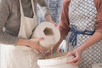 Due artisti della ceramica sono ceramica slipcasting in un laboratorio di ceramica . — Foto stock
