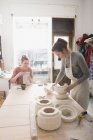 Deux céramistes travaillent sur leurs céramiques dans un atelier de poterie
. — Photo de stock
