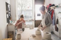 Due artisti della ceramica stanno lavorando alla loro ceramica in un laboratorio di ceramica
. — Foto stock