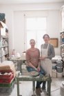 Deux artistes céramistes représentés dans leur atelier de poterie . — Photo de stock