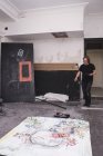 Kreativer männlicher Künstler, der in seiner Werkstatt arbeitet, während er im Raum geht — Stockfoto