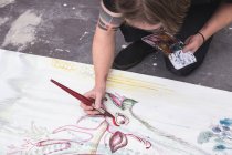 Artiste masculin créatif travaillant dans son atelier avec un pinceau à la main — Photo de stock