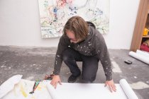 Kreativer männlicher Künstler, der in seiner Werkstatt arbeitet, während er nach unten schaut — Stockfoto