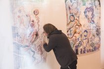 Artiste masculin créatif regardant son œuvre d'art et travaillant dans une galerie d'art — Photo de stock