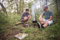 Deux hommes préparent le gril pour un barbecue en pleine nature . — Photo de stock