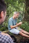 Un pescador está recogiendo una mosca de pesca de un aparejo de pesca con mosca . - foto de stock