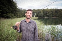 Conteúdo Pescador de moscas caucasiano com sua vara de pesca em um lago . — Fotografia de Stock