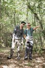 Dos hombres con equipo de pesca con mosca en la zona forestal . - foto de stock