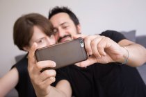 A young couple is doing selfies with a smart phone. — Stock Photo