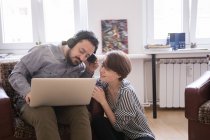 Um jovem casal está ouvindo música de um computador na sala de estar . — Fotografia de Stock