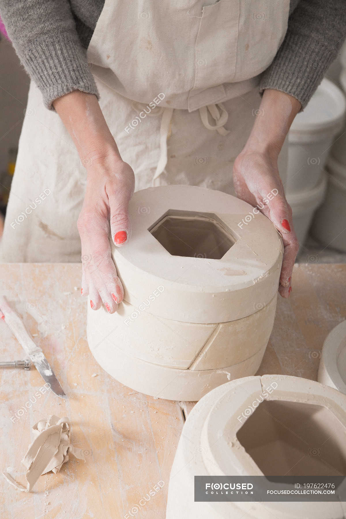 A ceramic artist is in the process of slipcasting ceramics in a pottery