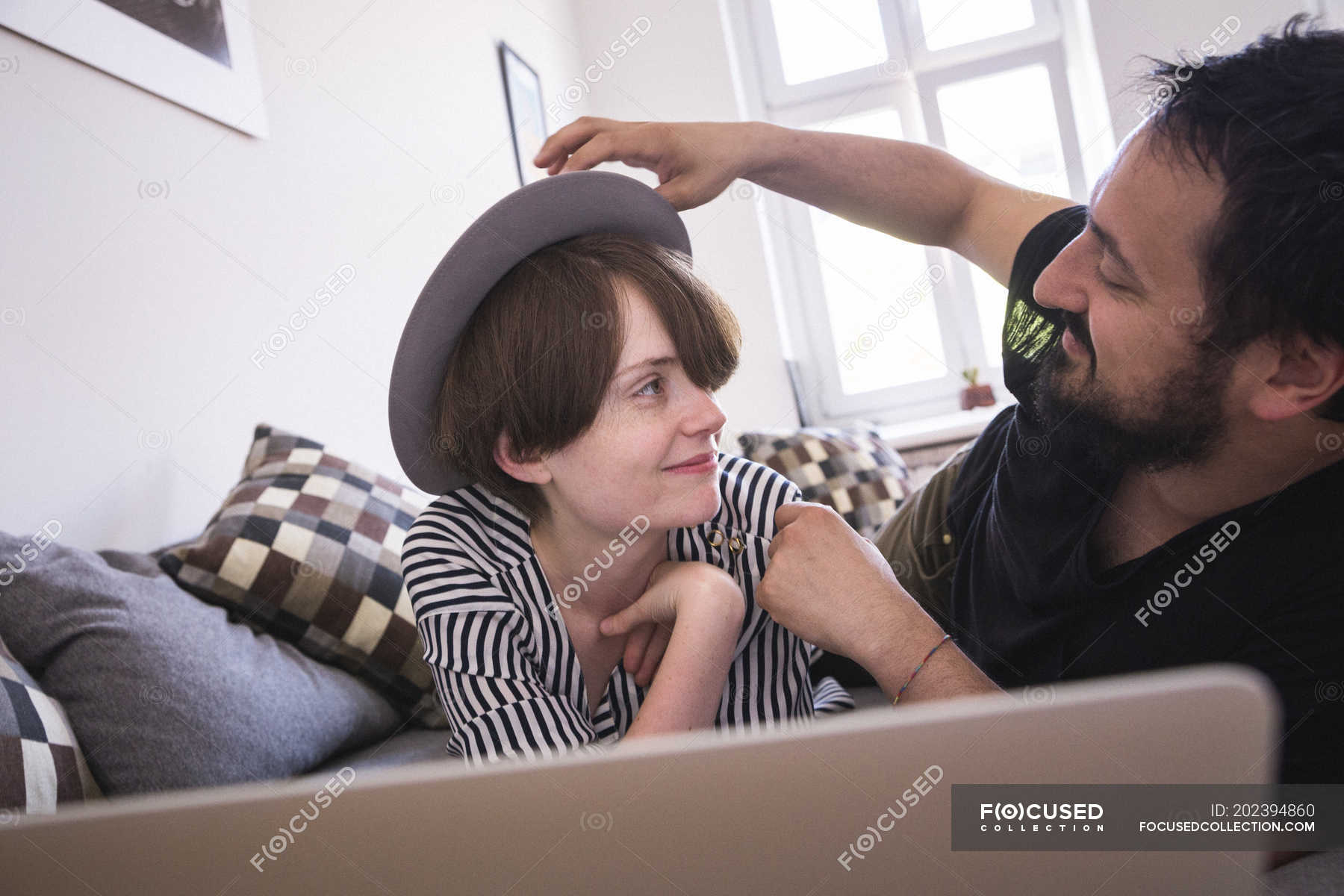 A Young Couple Is Streaming Tv Series On The Computer While