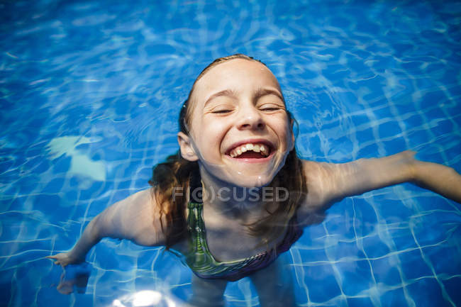 Uma menina está se divertindo em uma piscina durante as férias . — Fotografia de Stock