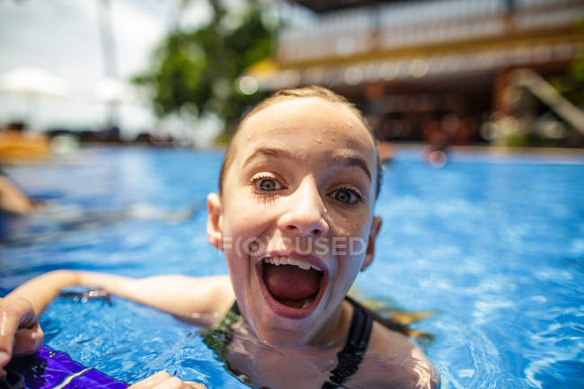 Una chica se está divirtiendo en una piscina durante las vacaciones . - foto de stock