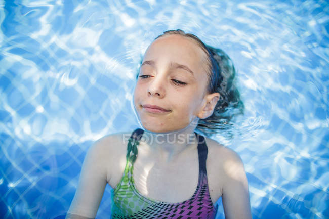 A girl is having fun in a swimming pool during vacation. — adventure ...