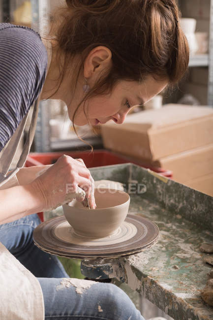 Кавказка формирует глину на гончарном круге в керамической мастерской . — стоковое фото