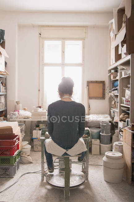 Кавказка формирует глину на гончарном круге в керамической мастерской
. — стоковое фото