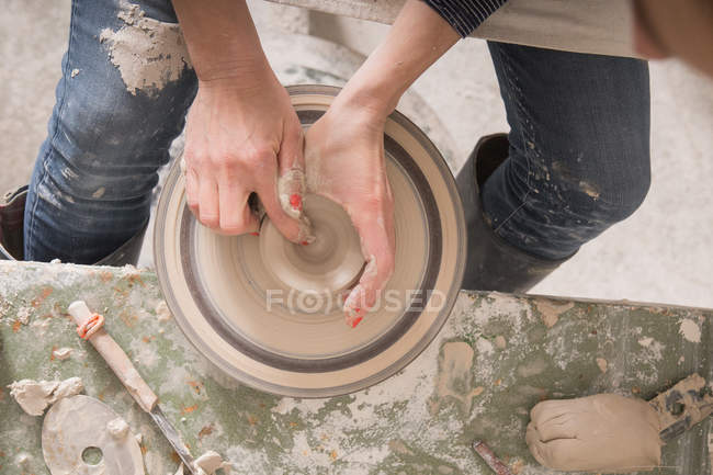 A ceramic artist shaping pottery clay on a pottery wheel in a ceramic workshop. — Stock Photo
