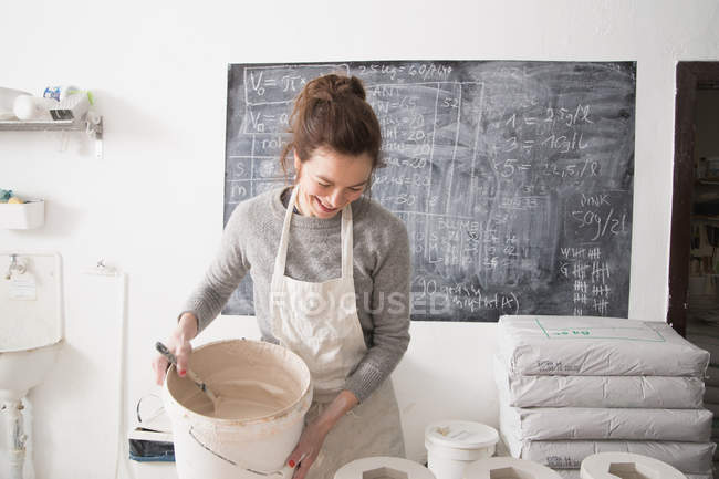 Un artista della ceramica è scivoloso ceramica in un laboratorio di ceramica
. — Foto stock