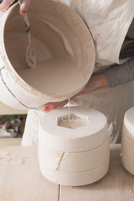 Um artista de cerâmica está escorregando cerâmica em uma oficina de cerâmica . — Fotografia de Stock